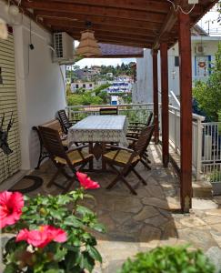 a table and chairs on a patio with flowers at Nikos Rooms in Votsi