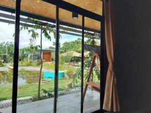 a room with a window looking out at a yard at Ban Bang Home Resort in Haad Chao Samran