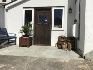 une porte d'une maison avec une plante en pot à côté de celle-ci dans l'établissement Dippy cottage, à Bexhill-on-Sea