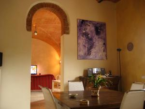 una sala da pranzo con tavolo in legno, sedie e dipinto viola di B&B Il Moscondoro a Montopoli in Val dʼArno