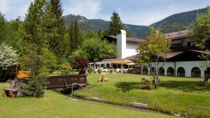 a building with a park with benches in a yard at Alpenhof Grainau in Grainau