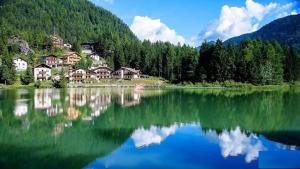 a reflection of houses in a large lake at Appartamento Italia in Alleghe