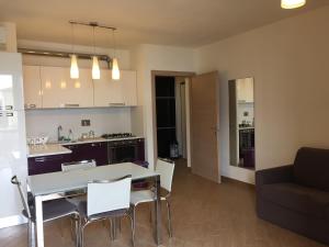 una cucina e un soggiorno con tavolo e sedie di Appartamento Elena a Pisa