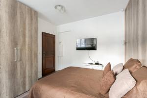 - une chambre avec un lit et une télévision murale dans l'établissement Charmant studio neuf proche Tour Eiffel (G36), à Paris