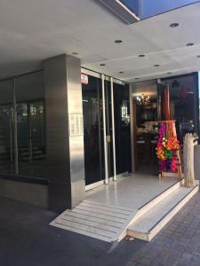 vestíbulo de un edificio con puertas de cristal y flores en Departamento Salta Capital en Salta