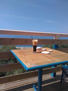 パラリア・ブラフにあるMarieva Sea Houseのベンチの上に座って飲み物を飲む