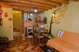 La Casa del Kender في Casas del Abad: غرفة مع طاولة ومطبخ مع شجرة على الحائط