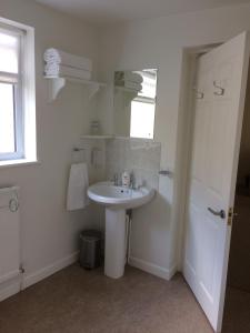 a white bathroom with a sink and a mirror at Little Manor in Cheltenham