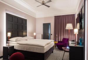 科隆的住宿－米德頓酒店，一间卧室配有一张大床和一张紫色椅子