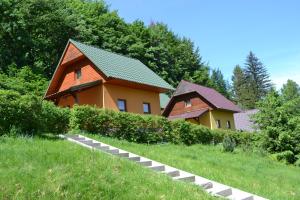 a couple of houses in a grassy field at Chaty pod Knížecí, Trojanovice in Trojanovice