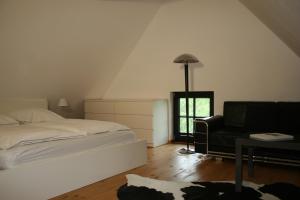 ein Schlafzimmer mit einem Bett, einem Stuhl und einem Fenster in der Unterkunft Gutshof Warthe in Warthe