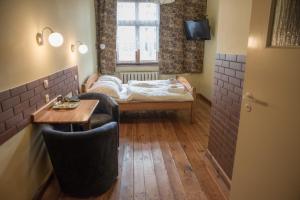 mały pokój z łóżkiem, stołem i krzesłami w obiekcie Hotel Azyl w mieście Gorzów Wielkopolski