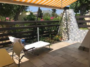 un patio con mesa, sillas y una valla en Village Naturiste Le Cap d'Agde villa Port Nature, en Cap d'Agde