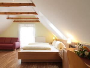 a bedroom with a bed and a red couch at Weingut Skoff Original in Gamlitz