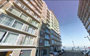 ein hohes Gebäude auf einer Straße neben dem Meer in der Unterkunft SeaWind in Middelkerke