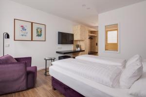 a bedroom with a large white bed and a couch at Hotel Central in Innsbruck