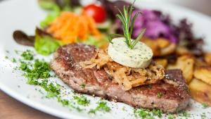 a plate of food with a piece of meat with a dollop of cheese at Hotel Wellness & Spa Nowy Dwór in Rzeszów