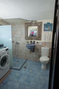 ein Badezimmer mit einem WC, einem Waschbecken und einer Waschmaschine in der Unterkunft Kritikies Elaia in Pitsidia