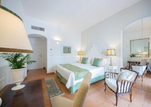 - une chambre avec un lit, une table et des chaises dans l'établissement Villa Romana Hotel & Spa, à Minori