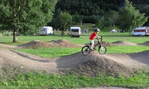 Ein Junge, der auf einem Haufen Dreck Fahrrad fährt. in der Unterkunft Folven Adventure Camp in Hjelle