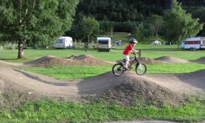 un chico montando una bicicleta en un montón de tierra en Folven Adventure Camp, en Hjelle