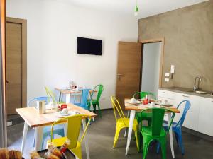 a dining room with tables and colorful chairs at Le Nereidi in Castellammare del Golfo