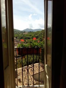 ein offenes Fenster mit einem Blumentopf auf dem Balkon in der Unterkunft Nenà Al Borgo Castello in Pico