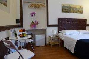 ローマにあるResidenza Vespasianoのベッドルーム1室(ベッド1台、テーブル、フルーツボウル付)
