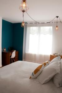 een slaapkamer met een groot wit bed en een raam bij Une chambre à Neuilly Guest house in Neuilly-Plaisance