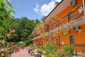 an orange building with flowers in front of it at Galicky Dvir Hotel in Svityazʼ
