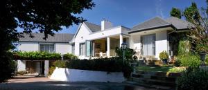 Casa blanca con porche y escaleras en Alba House Guest House, en Paarl