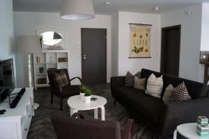 a living room with a black couch and chairs at Ferienhaus Hirtenstaller Düne in Büsum