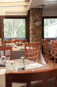 a dining room with tables and chairs and a stone wall at Kurparkhotel-Gemünd in Gemünd