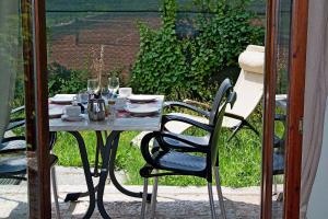 una mesa con sillas y vasos en un patio en Casa Orchidea Apartments en Torri del Benaco