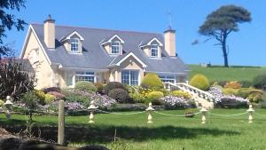 a house with a garden in front of it at Kilmacale House in Kilbrittain