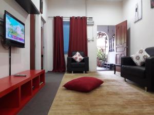 a living room with a couch and a tv at Alsafffa Homestay in Pantai Cenang