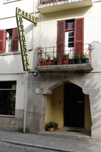 a building with a balcony with potted plants on it at Residencial Parque in Celorico da Beira