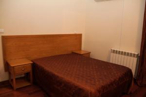 a bedroom with a bed and a wooden headboard at Residencial Parque in Celorico da Beira