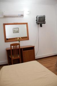 a bedroom with a bed and a tv on a wall at Residencial Parque in Celorico da Beira