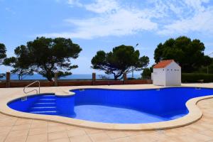 una piscina azul con árboles en el fondo en Rentalmar Los Angeles, en Miami Platja