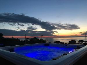 a jacuzzi tub with a sunset in the background at Hotel Crawford in Sant'Agnello