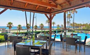 um restaurante com mesas e cadeiras e uma piscina em Sol Principe em Torremolinos