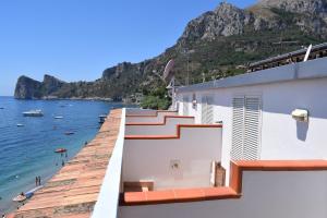 a building with stairs on the side of a beach at Hotel La Certosa in Massa Lubrense