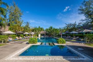 - une piscine avec des chaises et des parasols dans l'établissement Krabi Aquamarine Resort - SHA Plus, à Ao Nang Beach