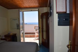 a room with a bed and a door to a balcony at Hotel La Certosa in Massa Lubrense