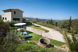 un giardino con piscina e tavolo e un edificio di Appartamento Anna Natura e Relax a Gonnesa