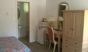 a bedroom with a desk and a bedroom with a bed at The Tallwood Motel in Wells