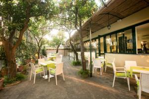 an outdoor patio with tables and chairs and trees at Hotel Crawford in Sant'Agnello