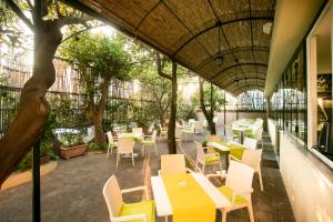 an outdoor patio with tables and chairs and trees at Hotel Crawford in Sant'Agnello
