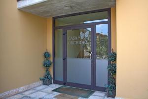 a door to a building with a sign on it at Casa Orchidea Apartments in Torri del Benaco